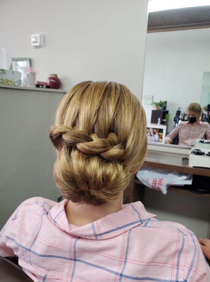 Blonde hair styled in a braided low bun