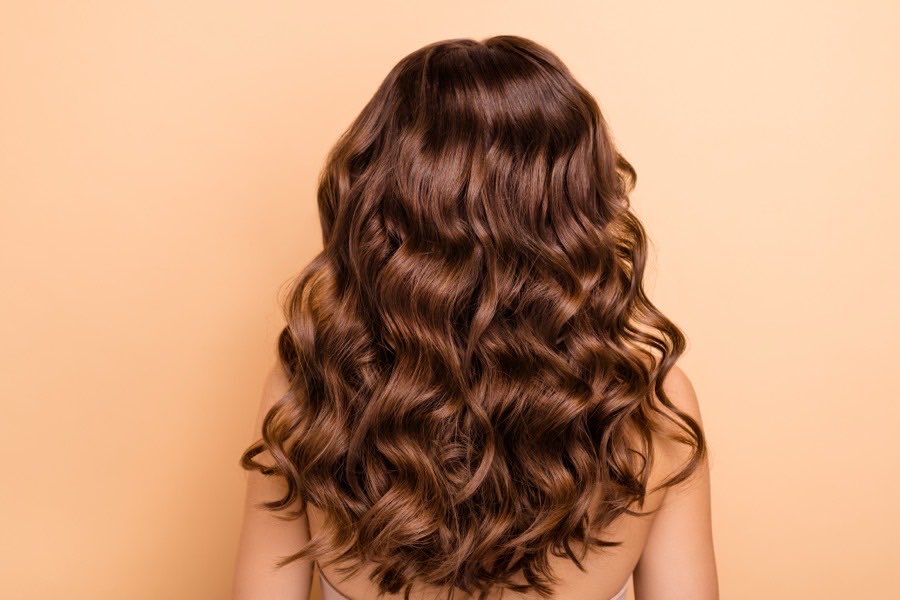 Long brunette hair styled in glossy waves